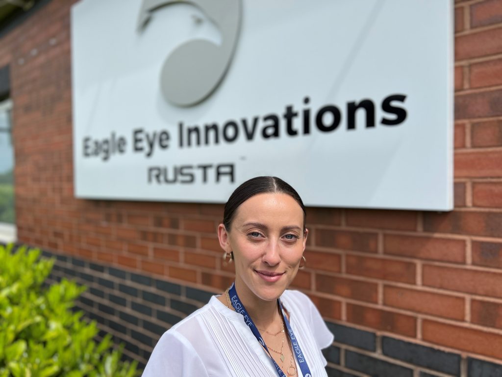Woman stood in front of Eagle Eye Innovations RUSTA sign.