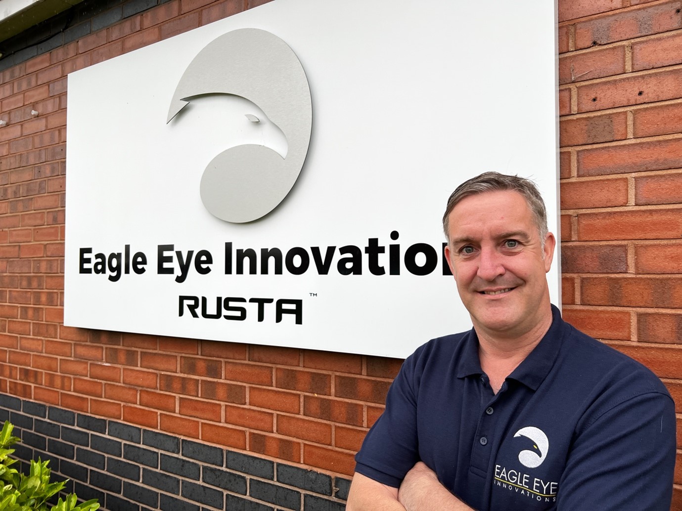 Man stood in front of Eagle Eye Innovations RUSTA sign.