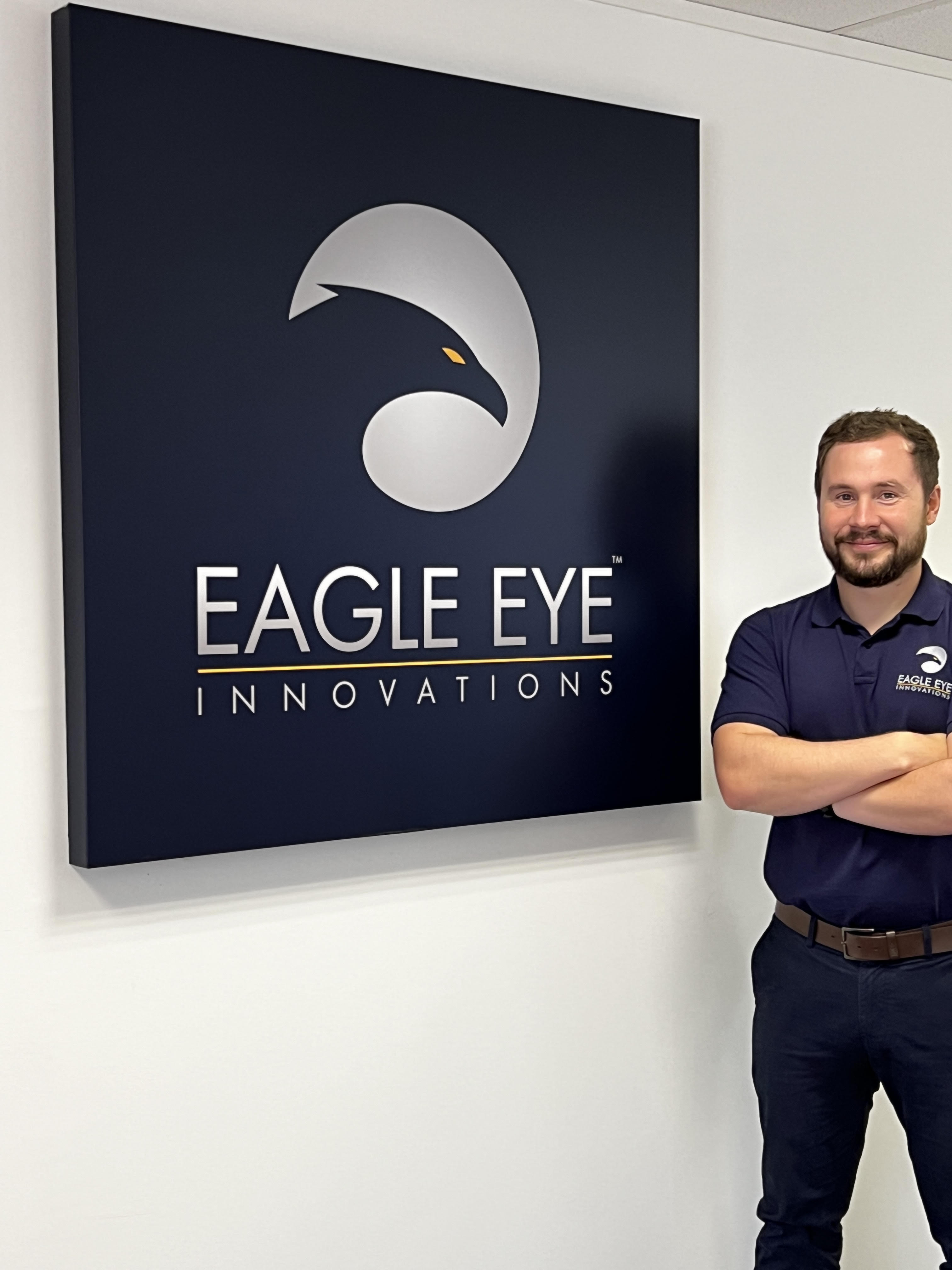 Man stood beside Eagle Eye Innovations sign.