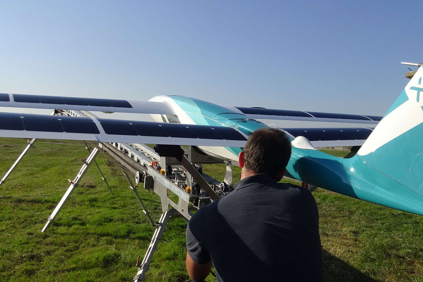 Image of man setting up a large fixed wing drone for take off.