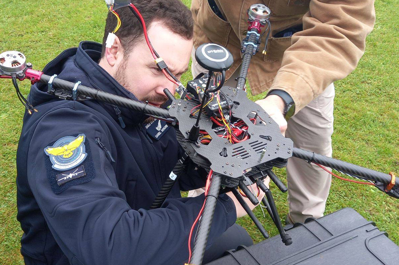 Man in Eagle Eye Innovations branded jacket performing test and evaluation processes on a drone.