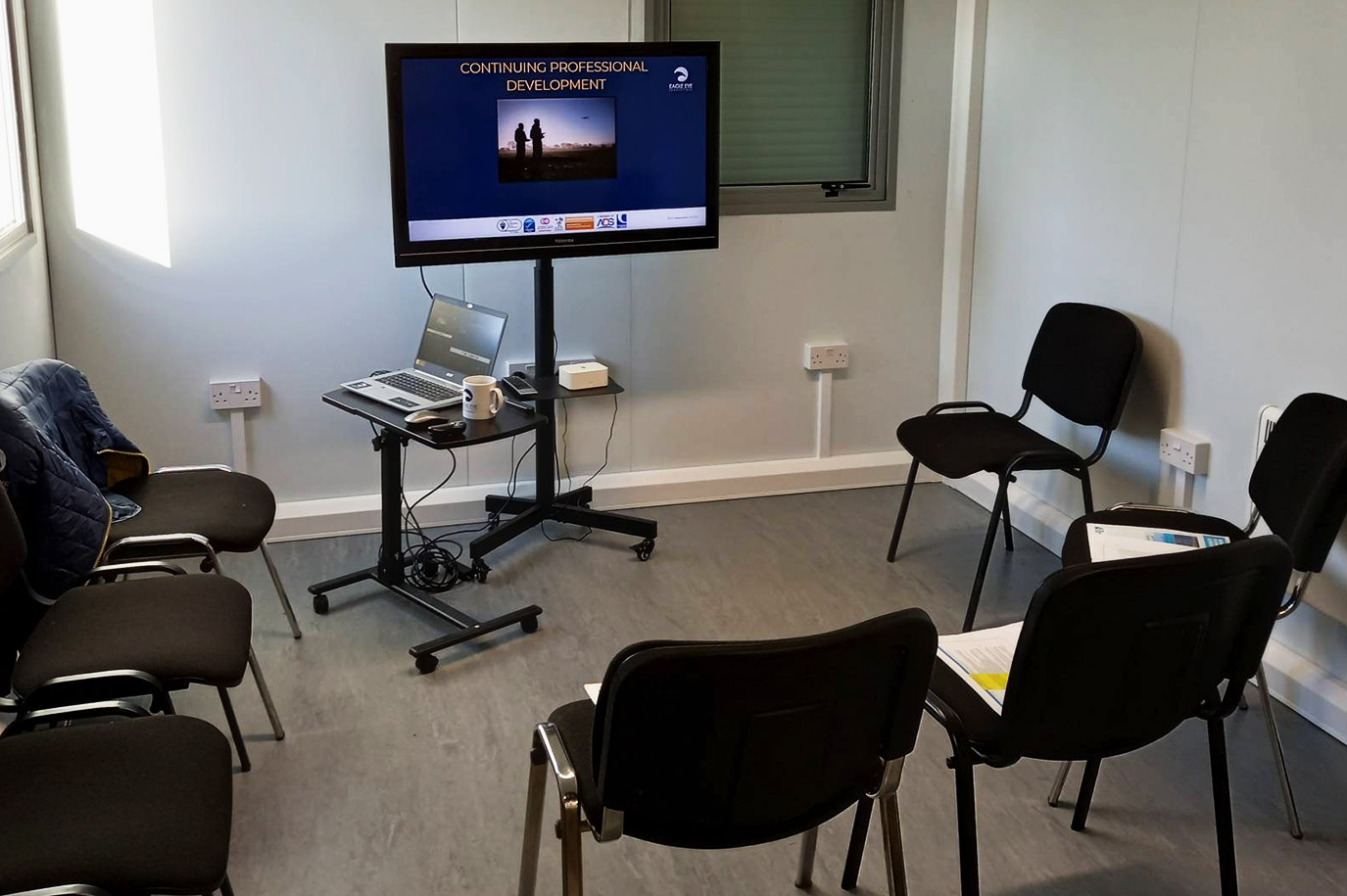 Image of classroom with screen set up at front of the room ready for a drone training.