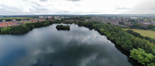 Image taken by a drone of a lake and village landscape in the area of North Hykeham.