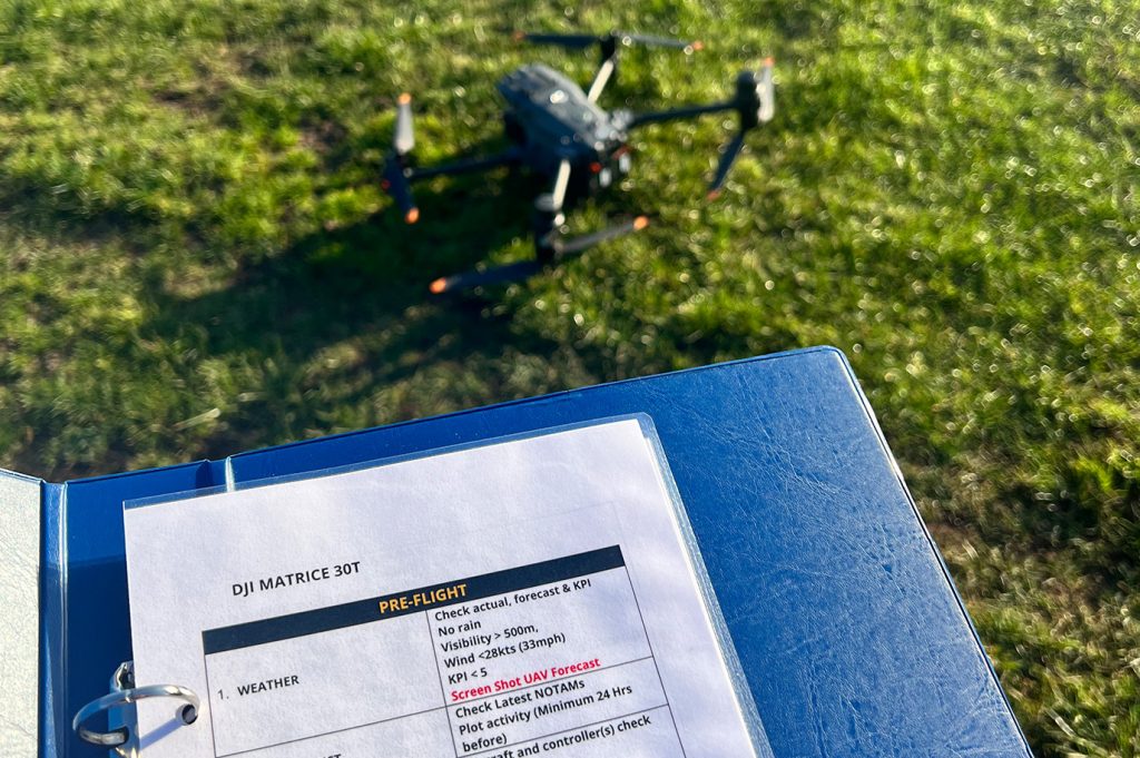 Image of blue folder open with a list of pre-flight checks for the Matrice 30T drone,