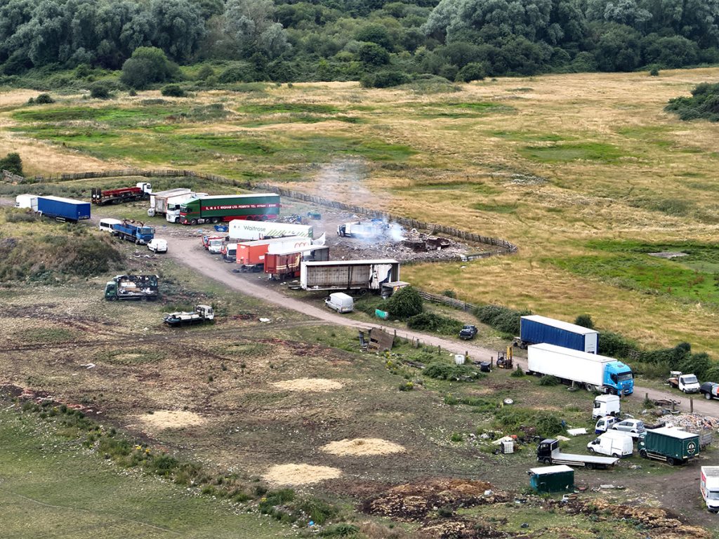 Drone shot of area with environmental waste and abandoned lorries.