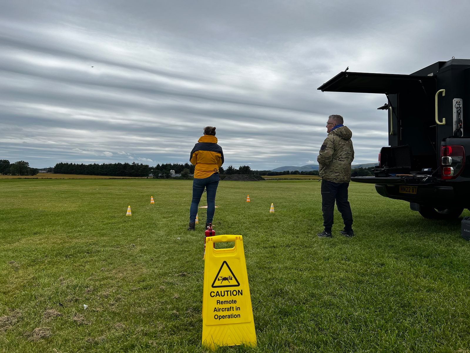 Zeta fast track course. Two people in field operating drone.
